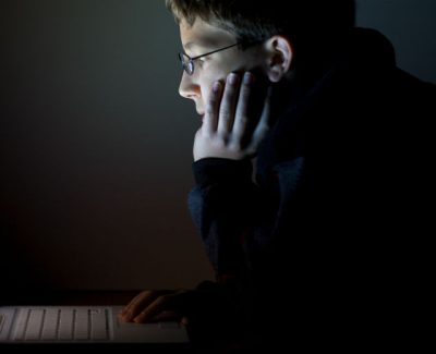 Young boy hacking on a computer