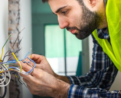 electrician fixing multiple wires coming out of the wall