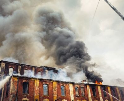 Factory on fire with smoke coming out of the top