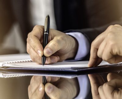Close up of hands of a businessman signing contract.