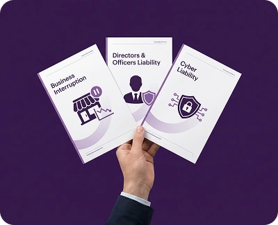 hand holding up three books one business interruption, directors and officers liability and cyber liability